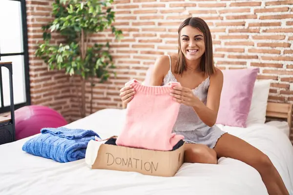Mujer Hispana Joven Poniendo Ropa Usada Caja Donaciones Sonriendo Riendo —  Fotos de Stock