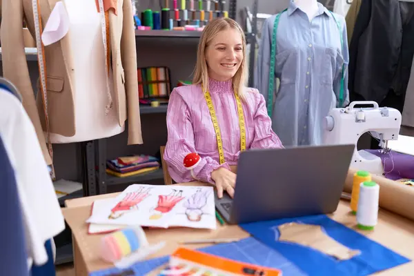 Young caucasian woman dressmaker designer using laptop with a happy and cool smile on face. lucky person.