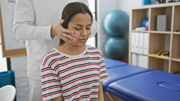 stock image A woman receives a neck examination from a female physiotherapist in a well-equipped rehabilitation clinic.