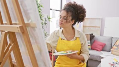 Kıvırcık saçlı, şüpheci İspanyol kadın sanatçı, alaycı bir şekilde şok olmuş görünüyor, stüdyoda oturuyor, ağzı sonuna kadar açık! Şüpheci, şaşkın ifade.