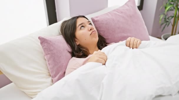 Молодая Латиноамериканка Просыпается Уютной Спальне Выглядит Сонной Удобной Белыми Постельными — стоковое видео