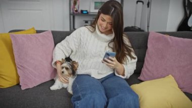 Köpekli İspanyol kadın evde akıllı telefondan selfie çekiyor.