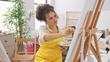 İspanyol kıvırcık saçlı kadın sanatçı, ağzı açık bağırıyor, stüdyo koltuğundan yüksek sesle bağırıyor, gözle görülür şekilde hayal kırıklığına uğruyor, elleri havada uçuşuyor, yandan iletişim kurarken duygularını delicesine açığa vuruyor..