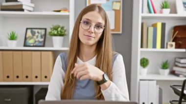 Acele et, zaman doldu! Sarışın iş adamı sabırsız bir şekilde ofisin içinde nöbet tutuyor, sakin bir yüz olmasına rağmen kameraya stres gecikmelerini işaret ediyor.