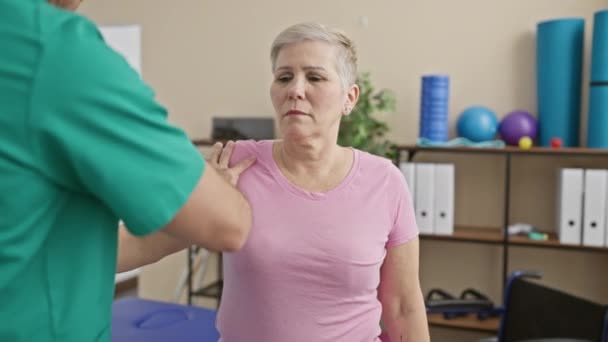Kobieta Otrzymuje Fizjoterapię Ramion Mężczyzny Klinice — Wideo stockowe