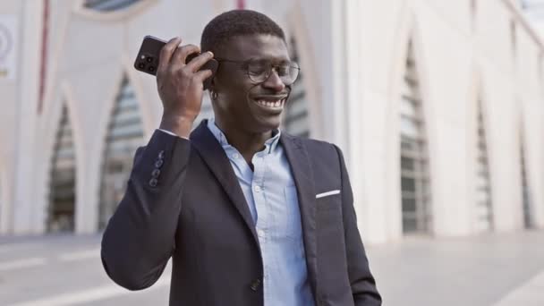 Leende Afrikansk Man Kostym Lyssnar Röstbrevlåda Utanför Modern Stadsbyggnad — Stockvideo