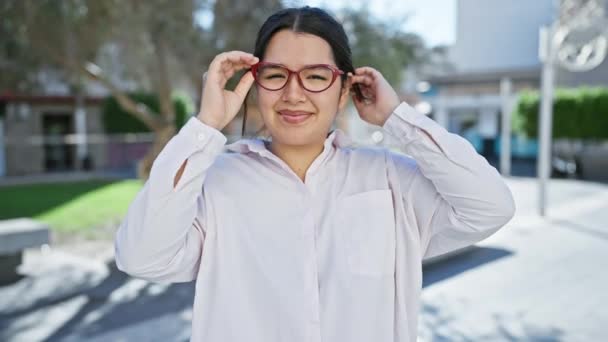 Smilende Ung Spansktalende Kvinde Justerer Briller Bygaden Legemliggør Skønhed Tillid – Stock-video