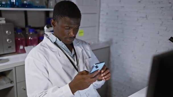 Африканский Мужчина Халате Использует Смартфон Современной Лабораторной Обстановке — стоковое видео