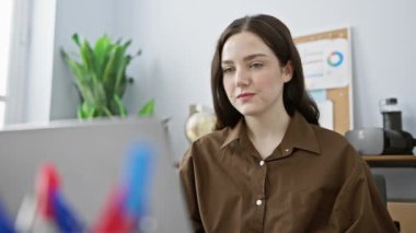 Modern ofis ortamında masasında özenle çalışan genç, profesyonel bir kadın..