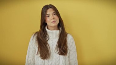 Sarı izole bir arka planda gururla duran göz kamaştırıcı, genç İspanyol bir kadın. Hoş bir gülümsemesi olan havalı bir kazağı var. Kendine güveni tam bir neşe saçıyor, pozitif yaşam tarzının vücut bulmuş hali..