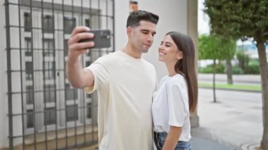 Şehirli bir sokakta selfie çeken, sevgi ve şehir yaşam tarzını sergileyen sevgi dolu bir çift..