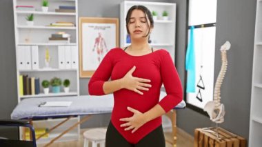 Genç bir İspanyol kadın bir rehabilitasyon kliniğinin iç kısımlarında solunum egzersizleri yapıyor. Sağlık ve terapiyi çağrıştırıyor..