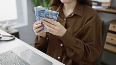 Genç bir kadın ofisindeki Macar banknotlarını değerlendiriyor, işyerindeki mali durumu gösteriyor..