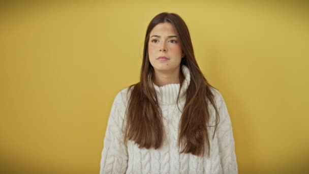 シンマー サプライズ 黄色の背景にある 驚くべき若いヒスパニック系の女性 口の痛みが先を指しています 彼女の偉大な発見の孤立したカットアウト セーターを身に着けている 観察者に忘れられない — ストック動画