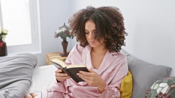Молода Іспаномовна Жінка Кучерявим Волоссям Читає Книгу Розслабляючись Затишній Спальні — стокове відео