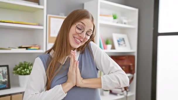 自信を持って若いブロンドのビジネス女性は オフィススペースで後ろを指摘しながら笑顔 屋内で成功を披露 — ストック動画