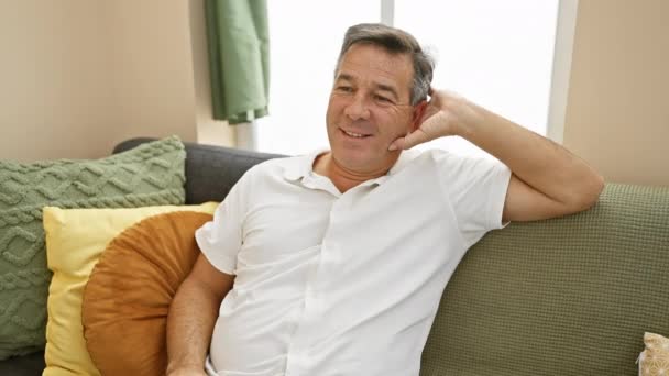 Hombre Mediana Edad Sonriente Descansando Cómodamente Sofá Una Sala Estar — Vídeos de Stock