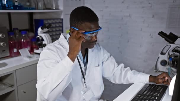 Cientista Masculino Africano Ajustando Óculos Segurança Enquanto Trabalhava Computador Laboratório — Vídeo de Stock