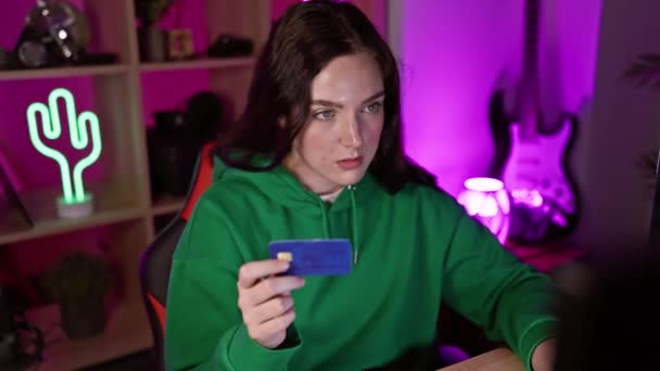 Een Jonge Vrouw Onderzoekt Een Creditcard Een Neon Verlichte Speelkamer — Stockvideo