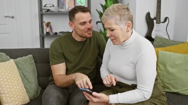 Žena Muž Spolu Zkoumají Smartphone Pohodlně Sedí Doma Šedém Gauči — Stock video