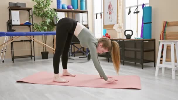 Una Giovane Donna Pratica Yoga Una Clinica Riabilitazione Luminosa Trasudando — Video Stock