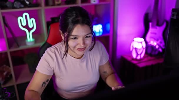 笑顔の若いヒスパニックの女性は 夜の活気に満ちたゲームルームで彼女の時間を楽しんで 喜びと現代的なライフスタイルの感覚を追加 — ストック動画