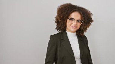 Kıvırcık saçlı neşeli İspanyol kadın, mutlu baş parmaklarıyla başarıyı gösteriyor. Beyazların üzerinde tek başına duruyor. Pozitif kadın kazanan, sana bakıyor, sanki 'tamam' diyor gibi!