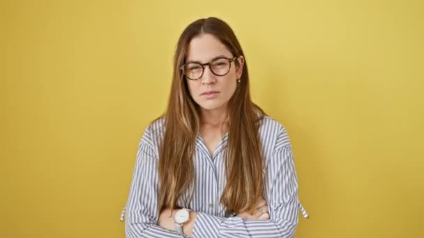 神経質な若い女性は 青い目に懐疑的で メガネをかけていて 問題をめちゃくちゃにしている 黄色い隔離された背景に対する否定的な人 — ストック動画