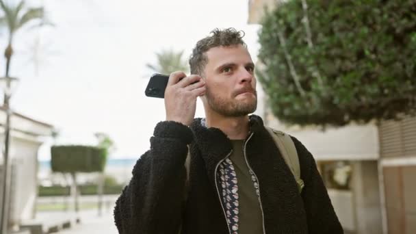 ハンサムなヒスパニックの男は 都市街のストリートセッティングでスマートフォンで話すひげを持つ — ストック動画