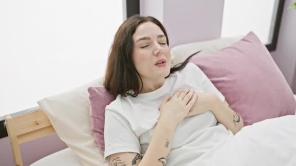 Mujer Joven Confiada Sentada Dormitorio Con Gesto Encantador Pequeño Tamaño — Vídeos de Stock