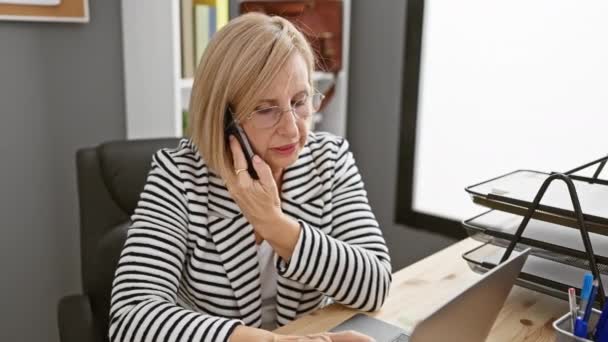 一个成熟 冷静的女人在她现代的办公室里通过电话做生意 — 图库视频影像