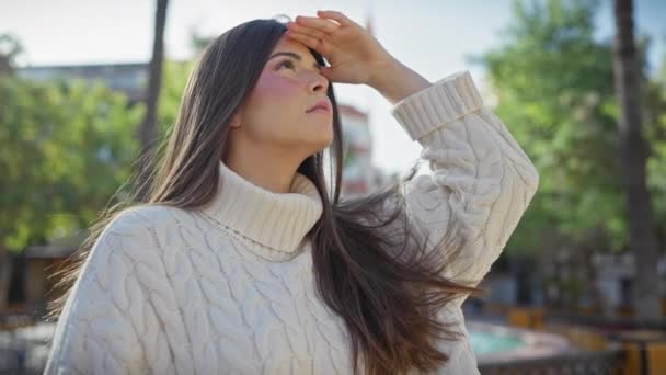 Young Woman Dressed Knit Sweater Gazes Upwards Sunlit Urban Park — Stock Video