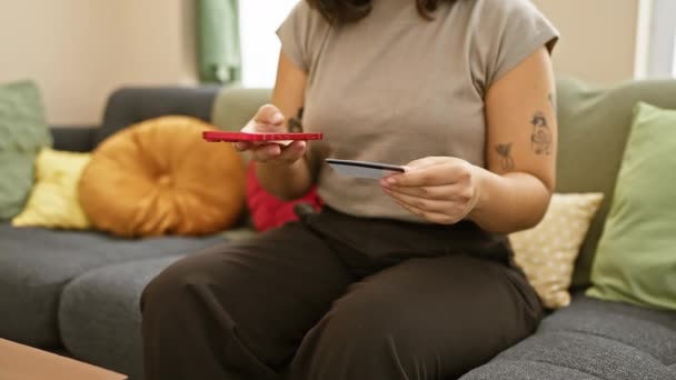 Latynoska Kobieta Kartą Kredytową Smartfonem Siedząca Kanapie Domu Tatuaże Widoczne — Wideo stockowe