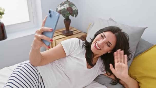 Усміхнена Жінка Бере Селфі Спальні Смартфоном Демонструючи Спокійний Спосіб Життя — стокове відео