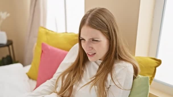 Заплутана Молода Блондинка Скептично Виглядає Опуклим Обличчі Сидячи Піжамі Вірячи — стокове відео