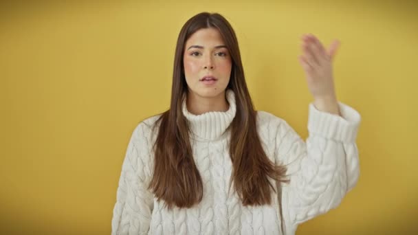 陽気な若いヒスパニック女性 黄色い隔離された背景の上に立って セーターを着て 幅広いグリンの彼女の目を覆い 盲目の男のブルフを再生する完璧な人 — ストック動画