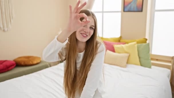 Pijama Giyen Neşeli Genç Sarışın Kadın Yatağa Oturur Parmaklarıyla Tamam — Stok video
