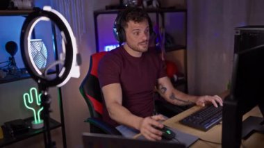 Odaklanmış, sakallı bir İspanyol adam geceleri oyun odasında çalışır. Kulaklık takıp bilgisayar ekranına dikkatle bakar..