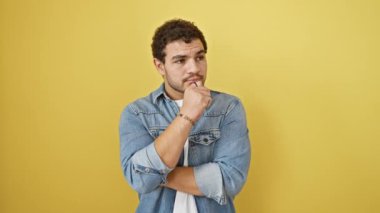 Kendinden geçmiş genç Arap adam, sarı izole edilmiş bir arka planda duruyor, parmağını bir numarayı işaret ediyor, parlak fikri üzerine başarı ve neşe saçıyor..