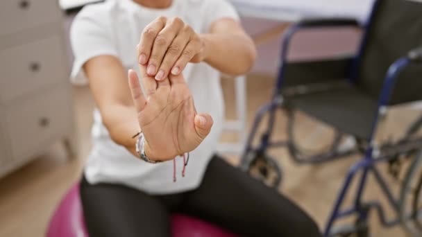 Hispanic Kvinna Utför Hand Stretching Övningar Ett Gym Boll Rehabiliteringsklinik — Stockvideo