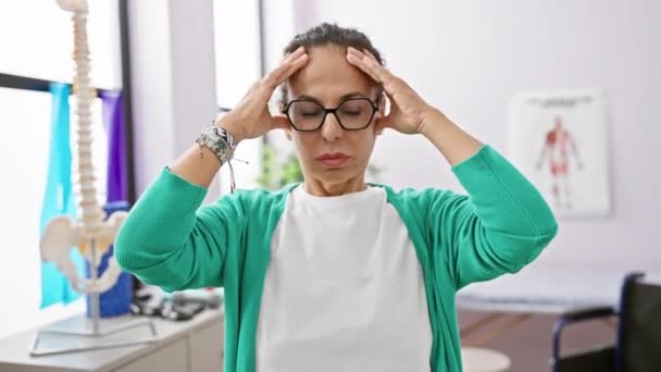 Αγχωμένη Μεσήλικη Ισπανίδα Φυσιοθεραπεύτρια Κλινική Αποτοξίνωσης Χέρι Στο Κεφάλι Που — Αρχείο Βίντεο