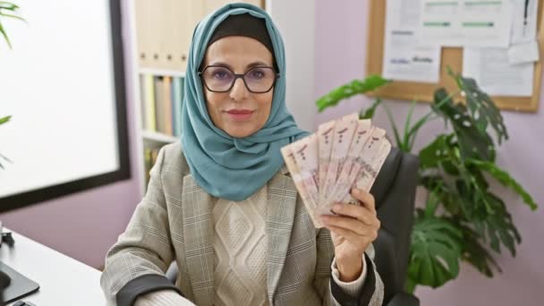 Confident Middle Aged Hispanic Woman Hijab Smiling Joy Holds Riyals — Stock Video