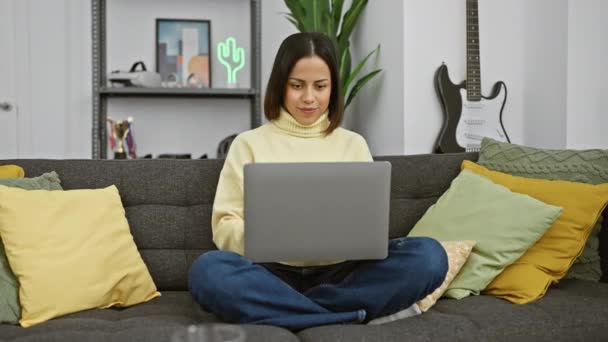 Uma Mulher Hispânica Sorridente Uma Camisola Amarela Confortavelmente Usando Laptop — Vídeo de Stock