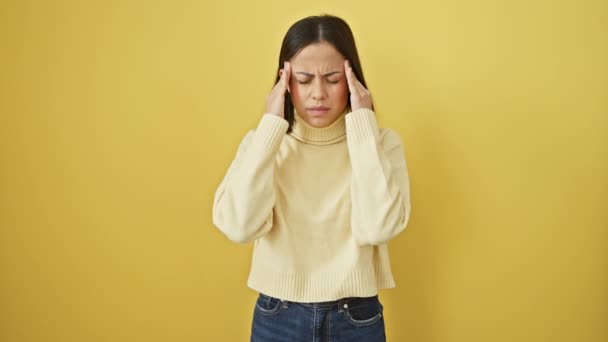 스웨터를 아름다운 히스패닉 스트레스와 편두통 머리에 노란색 배경에 통증으로 — 비디오