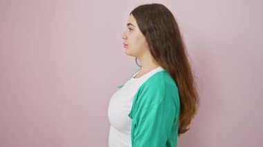 Kendinden emin, genç İspanyol bir kadın doğal bir poz veriyor. Güzel profili, izole edilmiş pembe bir arka planda bize bakıyor. Gülüşü samimi ve parlak.