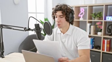 Radyo stüdyosunda çalışan kıvırcık saçlı İspanyol genç adam.