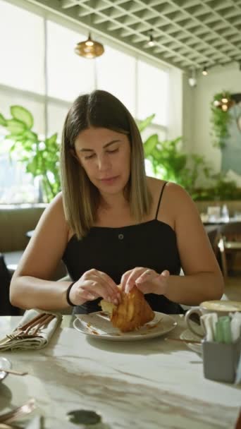 Jovem Mulher Desfrutando Croissant Café Chique Retratando Uma Cena Casual — Vídeo de Stock