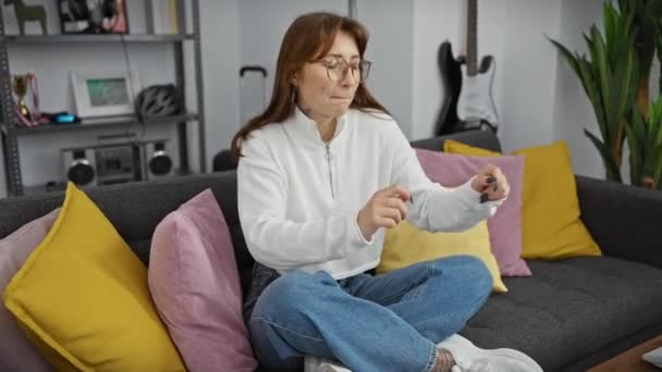 Μια Χαλαρή Νεαρή Γυναίκα Καθημερινά Ρούχα Κάθεται Έναν Καναπέ Στο — Αρχείο Βίντεο