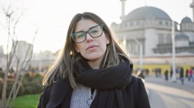 Altın saat boyunca İstanbul 'un simgesi önünde gözlüklü gülümseyen bir kadının portresi.