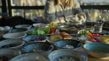 Geleneksel kahvaltı ve İstanbul manzaralı Türk restoranında yemek yiyen mutlu bir kadın..